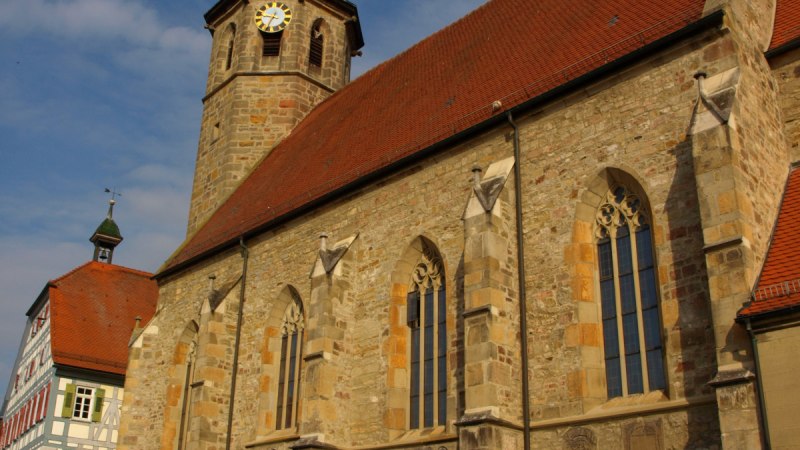 Die Evangelische Martinskirche mit gotischen Fenstern und einem Turm mit Uhr vor blauem Himmel., © Land der 1000 Hügel - Kraichgau-Stromberg Die Evangelische Martinskirche mit gotischen Fenstern und einem Turm mit Uhr vor blauem Himmel., © Land der 1000 Hügel - Kraichgau-Stromberg
