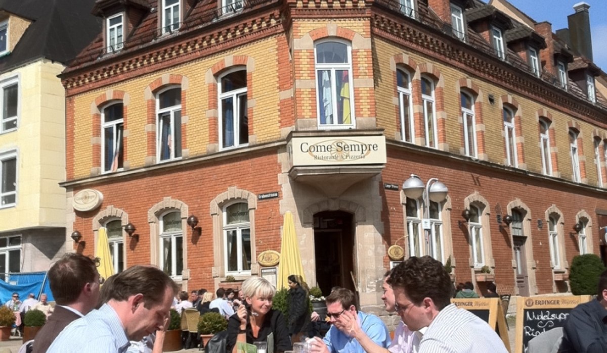 Menschen genießen das sonnige Wetter an einem Tisch vor dem historischen Gebäude 'Come Sempre' am Wettbachplatz in Sindelfingen., © Sindelfingen - Stuttgart-Marketing GmbH