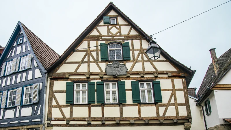 Fachwerkhäuser in Marbach am Neckar, darunter Schillers Geburtshaus mit grünem Fensterladen und historischem Schild., © SMG, Sarah Schmid Fachwerkhäuser in Marbach am Neckar, darunter Schillers Geburtshaus mit grünem Fensterladen und historischem Schild., © SMG, Sarah Schmid