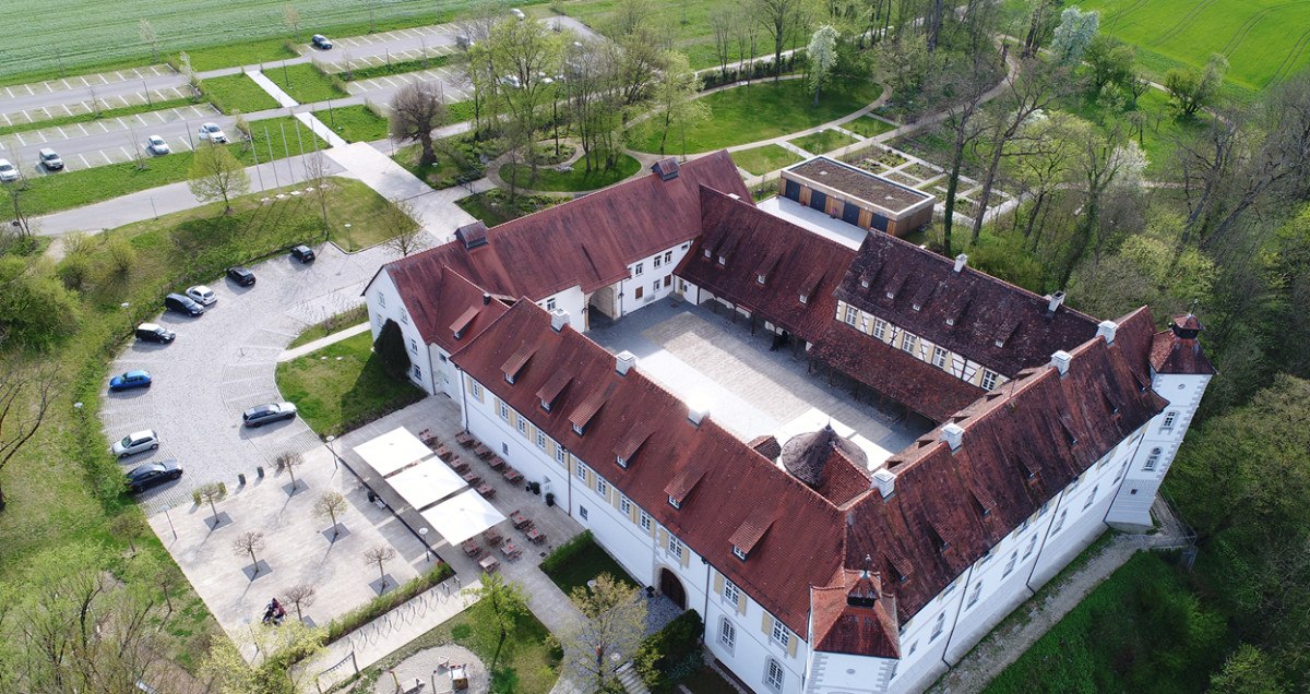 Luftaufnahme von Schloss Filseck mit rotem Dach und Innenhof, umgeben von Bäumen und Parkplätzen., © Landkreis Göppingen Luftaufnahme von Schloss Filseck mit rotem Dach und Innenhof, umgeben von Bäumen und Parkplätzen., © Landkreis Göppingen