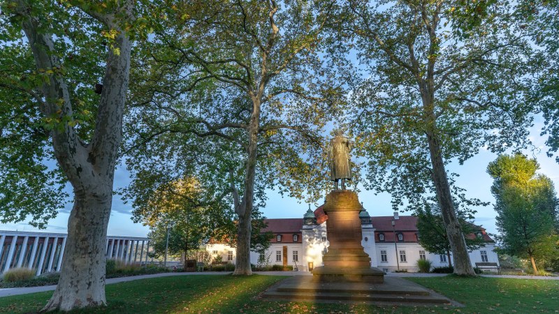 Das Schillerdenkmal steht vor dem Schiller-Nationalmuseum in Marbach, umgeben von hohen B&auml;umen und gr&uuml;nem Rasen., &copy; Stuttgart-Marketing GmbH, Martina Denker