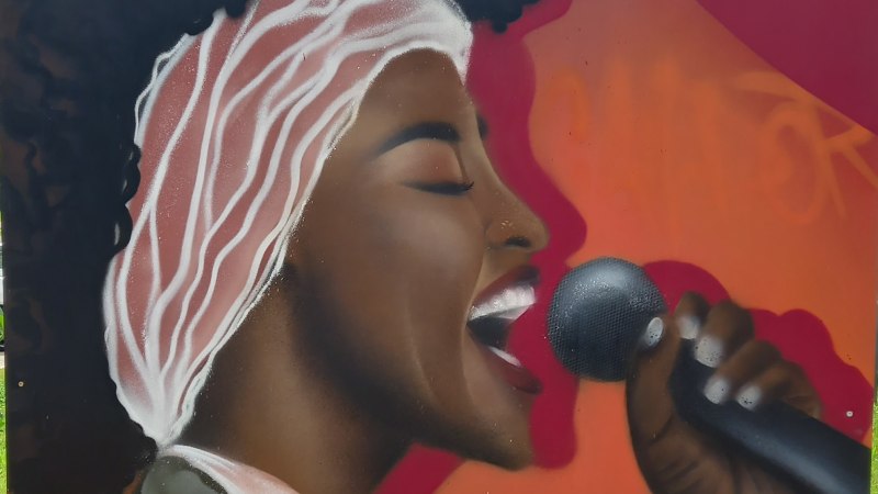 Gem&auml;lde einer Person of Color im Profil, mit hellem Tuch in den schwarzen Haaren - sie h&auml;lt ein Mikrofon in der linken Hand und singt, &copy; Petra Natzkowski