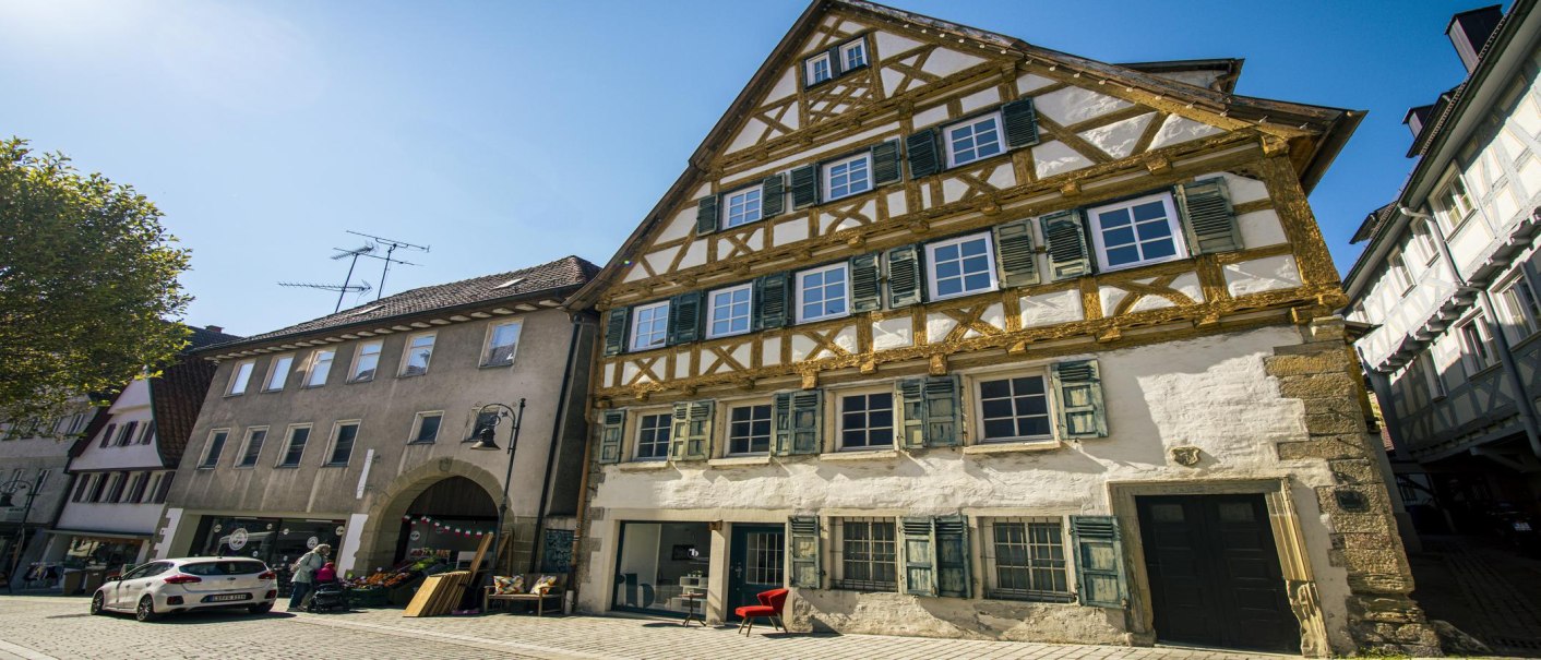 Außenansicht eines historischen Fachwerkhauses in Waiblingen, umgeben von anderen Gebäuden, bei strahlend blauem Himmel., © SMG, Sarah Schmid Außenansicht eines historischen Fachwerkhauses in Waiblingen, umgeben von anderen Gebäuden, bei strahlend blauem Himmel., © SMG, Sarah Schmid