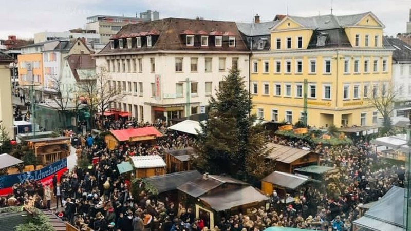 Ein belebter Weihnachtsmarkt in einer Stadt mit vielen Menschen, Buden und einem großen Weihnachtsbaum. Gebäude umgeben den Platz., © Stadt Göppingen Ein belebter Weihnachtsmarkt in einer Stadt mit vielen Menschen, Buden und einem großen Weihnachtsbaum. Gebäude umgeben den Platz., © Stadt Göppingen