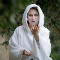 Eine Person in einem wei&szlig;en Geisterkost&uuml;m steht im Schlosspark und gestikuliert geheimnisvoll. Der Hintergrund ist gr&uuml;n und unscharf., &copy; &copy; T&E, Benjamin Stollenberg