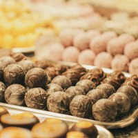 Eine Auswahl an Pralinen und Marzipan in verschiedenen Farben und Formen auf Tabletts pr&auml;sentiert., &copy; Frischmann-Marzipan-GmbH