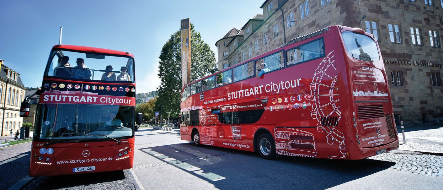 Zwei rote Doppeldeckerbusse der Stuttgart Citytour stehen vor dem Landesmuseum Württemberg. Menschen sitzen auf dem offenen Oberdeck., © Stuttgart-Marketing GmbH, Pierre Polak Zwei rote Doppeldeckerbusse der Stuttgart Citytour stehen vor dem Landesmuseum Württemberg. Menschen sitzen auf dem offenen Oberdeck., © Stuttgart-Marketing GmbH, Pierre Polak