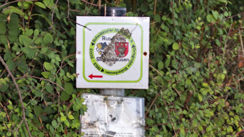 Ein Wegweiser im Geb&uuml;sch zeigt den Rundweg 'Rund um Sickenhausen' an. Der Pfeil weist nach links., &copy; Mythos Schw&auml;bische Alb