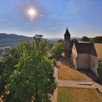 Kloster Lorch im Sonnenschein, umgeben von Bäumen und Hügeln. Im Hintergrund eine Stadt und bewaldete Hügel., © Stuttgart-Marketing GmbH, Achim Mende