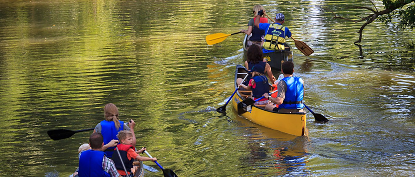 Zwei Kanus mit Menschen paddeln auf einem ruhigen Fluss. Die Personen tragen Schwimmwesten und genießen die Natur., © WTM GmbH Waiblingen