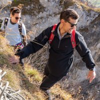 Zwei Personen klettern an einem steilen Hang. Eine Person trägt einen roten Rucksack. Ein Seil liegt auf dem Boden., © SMG, Martina Denker