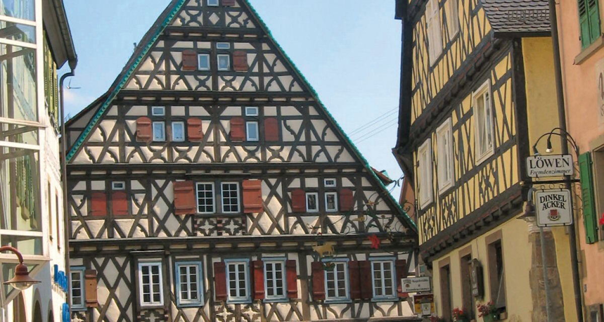 Fachwerkhäuser in Vaihingen-Enzweihingen, Deutschland. Ein Mann überquert die Straße bei sonnigem Wetter. Historische Architektur im Vordergrund., © Land der 1000 Hügel - Kraichgau-Stromberg Fachwerkhäuser in Vaihingen-Enzweihingen, Deutschland. Ein Mann überquert die Straße bei sonnigem Wetter. Historische Architektur im Vordergrund., © Land der 1000 Hügel - Kraichgau-Stromberg