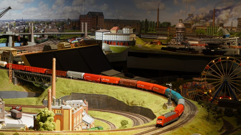Detailreiche Modelleisenbahnlandschaft mit Zügen, Gebäuden und einem Riesenrad. Die Szene zeigt eine lebendige Miniaturwelt mit Industrie- und Stadtlandschaften., © PMW Winnenden e.V. Detailreiche Modelleisenbahnlandschaft mit Zügen, Gebäuden und einem Riesenrad. Die Szene zeigt eine lebendige Miniaturwelt mit Industrie- und Stadtlandschaften., © PMW Winnenden e.V.