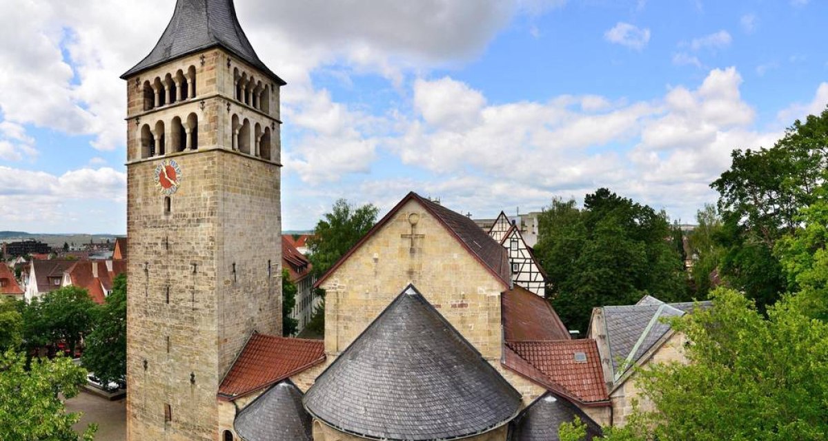 Historische Kirche mit hohem Turm und Spitzdach, umgeben von Bäumen und Fachwerkhäusern, unter einem bewölkten Himmel., © Natur.Nah. Schönbuch & Heckengäu