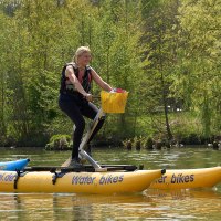 Zwei Personen fahren auf gelben Wasserfahrrädern auf einem Fluss. Sie tragen Schwimmwesten und sind von grüner Natur umgeben., © Foto LKZ - Fotograf Andreas Becker