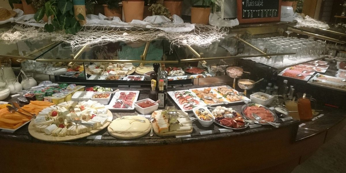 Ein reichhaltiges Frühstücksbuffet mit Käse, Aufschnitt, Obst und Brot. Verschiedene Speisen sind auf Tellern und in Schalen angerichtet., © Hotel Unger
