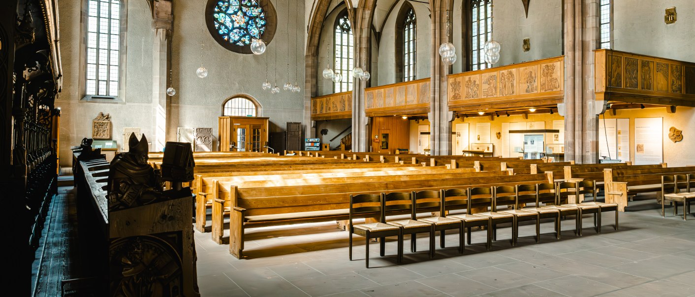 Innenansicht der Leonardskirche mit Holzbänken, Buntglasfenstern und hölzernen Deckenbalken. Die Architektur ist gotisch geprägt., © SMG Stuttgart Marketing GmbH - Sarah Schmid Innenansicht der Leonardskirche mit Holzbänken, Buntglasfenstern und hölzernen Deckenbalken. Die Architektur ist gotisch geprägt., © SMG Stuttgart Marketing GmbH - Sarah Schmid
