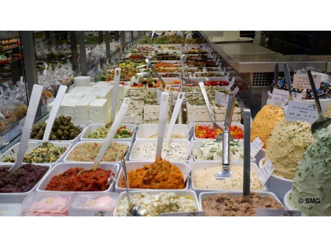 Verschiedene Dips und Aufstriche in einer Markthalle. Bunte Vielfalt in weißen Behältern, darunter Oliven, Käse und Kräuter., © Stuttgart Marketing GmbH Verschiedene Dips und Aufstriche in einer Markthalle. Bunte Vielfalt in weißen Behältern, darunter Oliven, Käse und Kräuter., © Stuttgart Marketing GmbH
