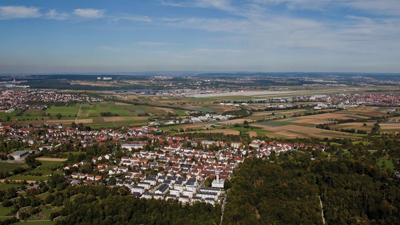 Luftaufnahme von Leinfelden-Echterdingen: Wohngebiete, Felder und ein Flughafen im Hintergrund unter blauem Himmel., © Stuttgart-Marketing GmbH