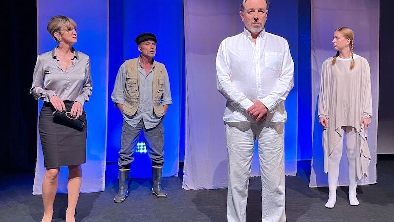 Vier Personen stehen auf einer B&uuml;hne vor blauem Hintergrund. Sie tragen unterschiedliche Outfits: elegant, l&auml;ssig und wei&szlig;. Die Szene wirkt dramatisch., &copy; Stadthalle Leonberg