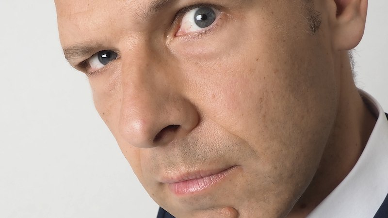 Nahaufnahme eines Mannes mit ernstem Blick, der direkt in die Kamera schaut. Der Hintergrund ist neutral gehalten., &copy; Dieselstrasse Kulturzentrum e.V.