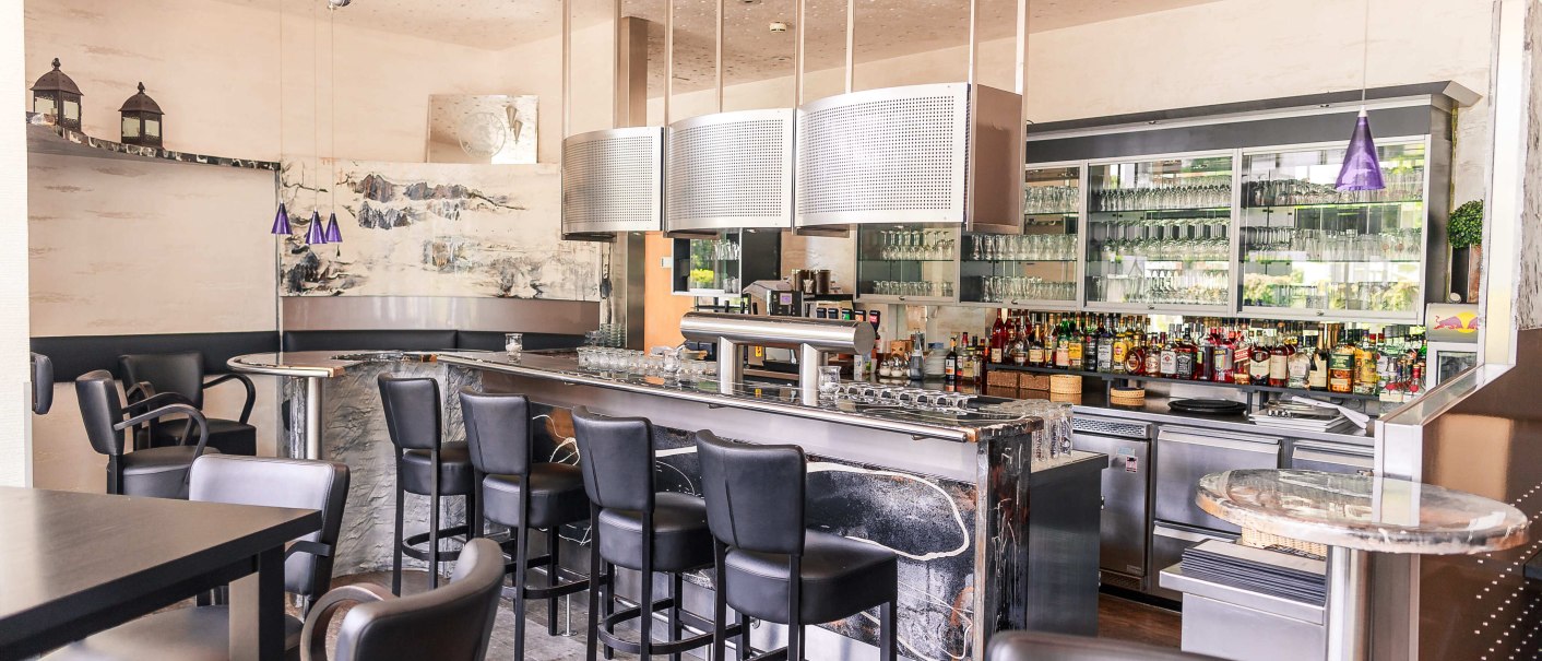 Moderne Bar mit schwarzen Stühlen, Marmortheke und gut bestücktem Regal mit Gläsern und Flaschen., © Plaza Residence Stuttgart-Ditzingen Moderne Bar mit schwarzen Stühlen, Marmortheke und gut bestücktem Regal mit Gläsern und Flaschen., © Plaza Residence Stuttgart-Ditzingen