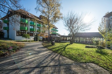 Gebäude mit grünen Balkonen, umgeben von Bäumen und Rasen, bei sonnigem Wetter., © Hotel am Schlossberg Herrenberg Gebäude mit grünen Balkonen, umgeben von Bäumen und Rasen, bei sonnigem Wetter., © Hotel am Schlossberg Herrenberg