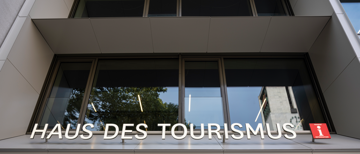 Moderne Fassade des Haus des Tourismus mit großem Schriftzug und Tourist-Information-Schild., © Stuttgart-Marketing GmbH, Sarah Schmid