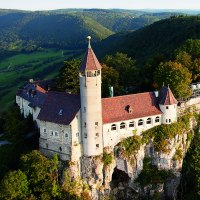 Die Burg Teck thront majestätisch auf einem bewaldeten Hügel, umgeben von grünen Tälern und Wäldern in der Ferne., © © Stuttgart-Marketing GmbH Die Burg Teck thront majestätisch auf einem bewaldeten Hügel, umgeben von grünen Tälern und Wäldern in der Ferne., © © Stuttgart-Marketing GmbH