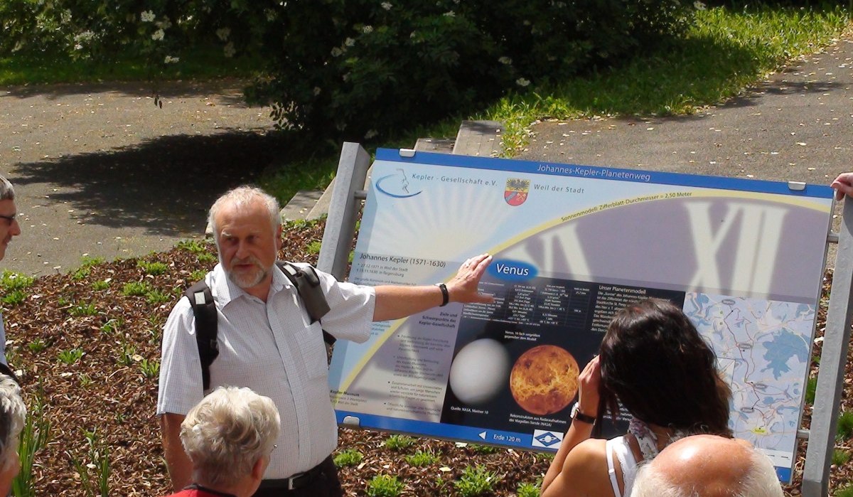 Ein Mann zeigt einer Gruppe eine Tafel über die Venus auf dem Johannes-Kepler-Planetenweg. Die Tafel enthält Bilder und Informationen., © Natur.Nah. Schönbuch & Heckengäu Ein Mann zeigt einer Gruppe eine Tafel über die Venus auf dem Johannes-Kepler-Planetenweg. Die Tafel enthält Bilder und Informationen., © Natur.Nah. Schönbuch & Heckengäu