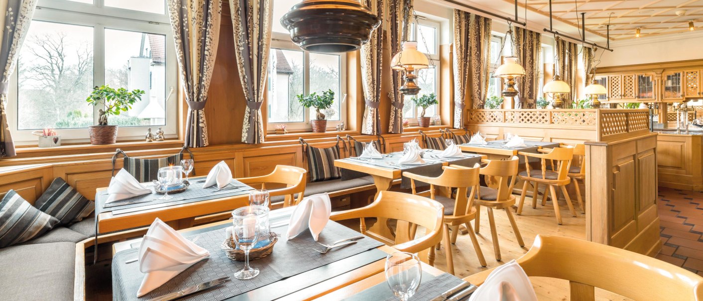 Gemütliches Restaurant mit Holzmöbeln, großen Fenstern und elegant gedeckten Tischen. Vorhänge und Pflanzen verleihen eine einladende Atmosphäre., © Seminaris Hotel Bad Boll Gemütliches Restaurant mit Holzmöbeln, großen Fenstern und elegant gedeckten Tischen. Vorhänge und Pflanzen verleihen eine einladende Atmosphäre., © Seminaris Hotel Bad Boll