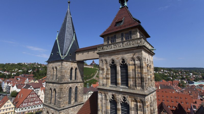 Zwei markante Kirchtürme in Esslingen, umgeben von roten Dächern und Fachwerkhäusern, unter blauem Himmel., © Esslinger Stadtmarketing & Tourismus GmbH