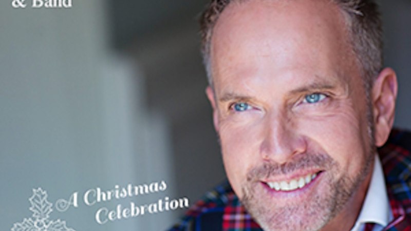 Mann in kariertem Anzug mit Fliege, lächelnd. Text: Kevin Tarte & Band, A Christmas Celebration., © Hirschsee Productions Mann in kariertem Anzug mit Fliege, lächelnd. Text: Kevin Tarte & Band, A Christmas Celebration., © Hirschsee Productions