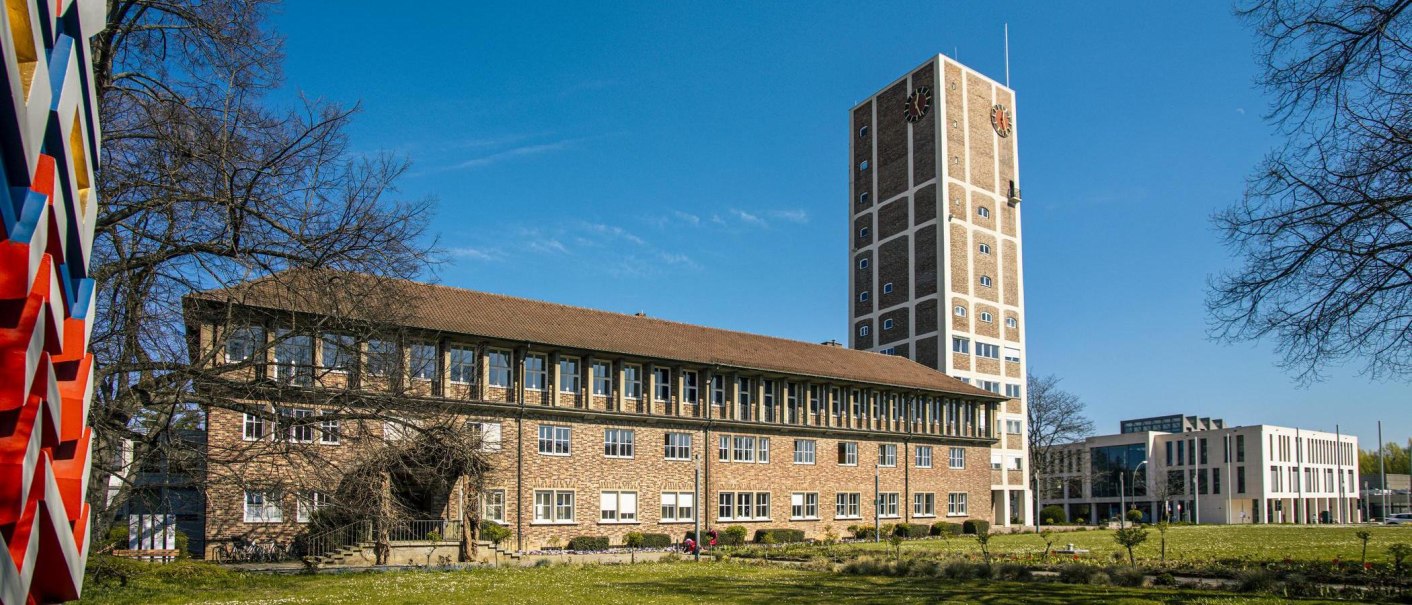 Das Rathaus Kornwestheim mit Turm und modernem Anbau, umgeben von Bäumen und einer Wiese unter blauem Himmel., © SMG, Sarah Schmid Das Rathaus Kornwestheim mit Turm und modernem Anbau, umgeben von Bäumen und einer Wiese unter blauem Himmel., © SMG, Sarah Schmid
