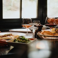 Zwei Personen genie&szlig;en ein Essen in einem Restaurant. Auf dem Tisch stehen Wein, Brot und Salat. Die Atmosph&auml;re wirkt gem&uuml;tlich und elegant., &copy; Stuttgart-Marketing GmbH, Alwin Maigler