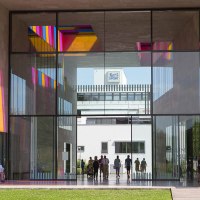 Glaspassage im Museum Ritter mit bunten Lichtreflexionen. Menschen gehen durch die Passage, im Hintergrund ist das Ritter Sport Logo sichtbar., © Region Stuttgart