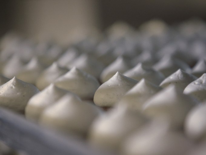 Reihe von kleinen, weißen Baiserhäubchen auf einem Backblech, die gleichmäßig angeordnet sind., © Stadt Göppingen Reihe von kleinen, weißen Baiserhäubchen auf einem Backblech, die gleichmäßig angeordnet sind., © Stadt Göppingen