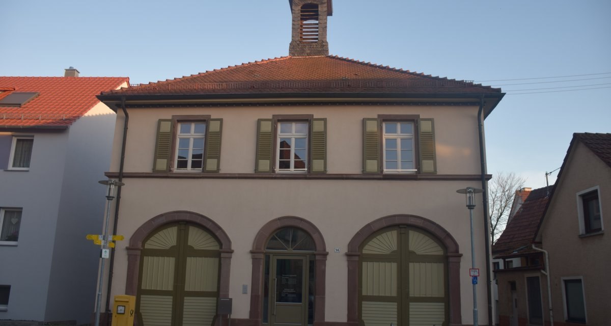 Ein zweistöckiges Gebäude mit rotem Ziegeldach und grünen Fensterläden, das als Rathaus dient., © Land der 1000 Hügel - Kraichgau-Stromberg Ein zweistöckiges Gebäude mit rotem Ziegeldach und grünen Fensterläden, das als Rathaus dient., © Land der 1000 Hügel - Kraichgau-Stromberg