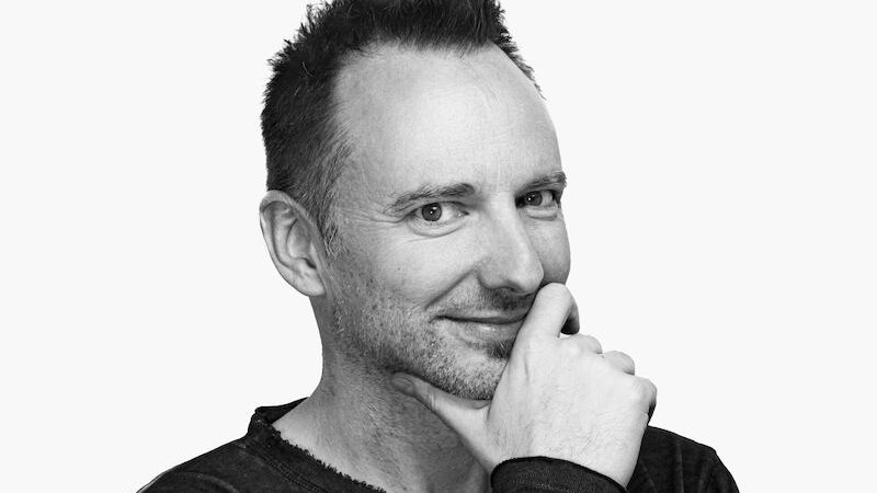 Ein Mann mit kurzem Haar l&auml;chelt und legt seine Hand ans Kinn. Er tr&auml;gt ein dunkles Oberteil vor einem wei&szlig;en Hintergrund., &copy; Stadtverwaltung Marbach