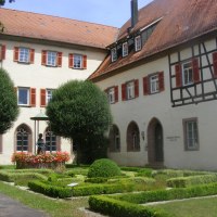 Historisches Gebäude mit Fachwerk und rotem Dach in Bad Mergentheim. Gepflegter Garten mit Brunnen und Blumen im Vordergrund., © Natur.Nah. Schönbuch & Heckengäu
