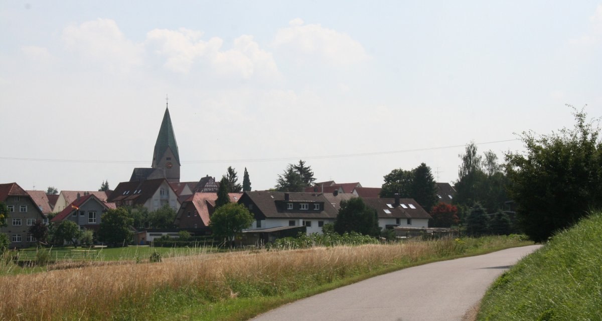 Ein Dorf mit einer Kirche im Hintergrund, umgeben von Häusern und Bäumen. Ein Weg führt durch eine Wiese im Vordergrund., © Natur.Nah. Schönbuch & Heckengäu Ein Dorf mit einer Kirche im Hintergrund, umgeben von Häusern und Bäumen. Ein Weg führt durch eine Wiese im Vordergrund., © Natur.Nah. Schönbuch & Heckengäu
