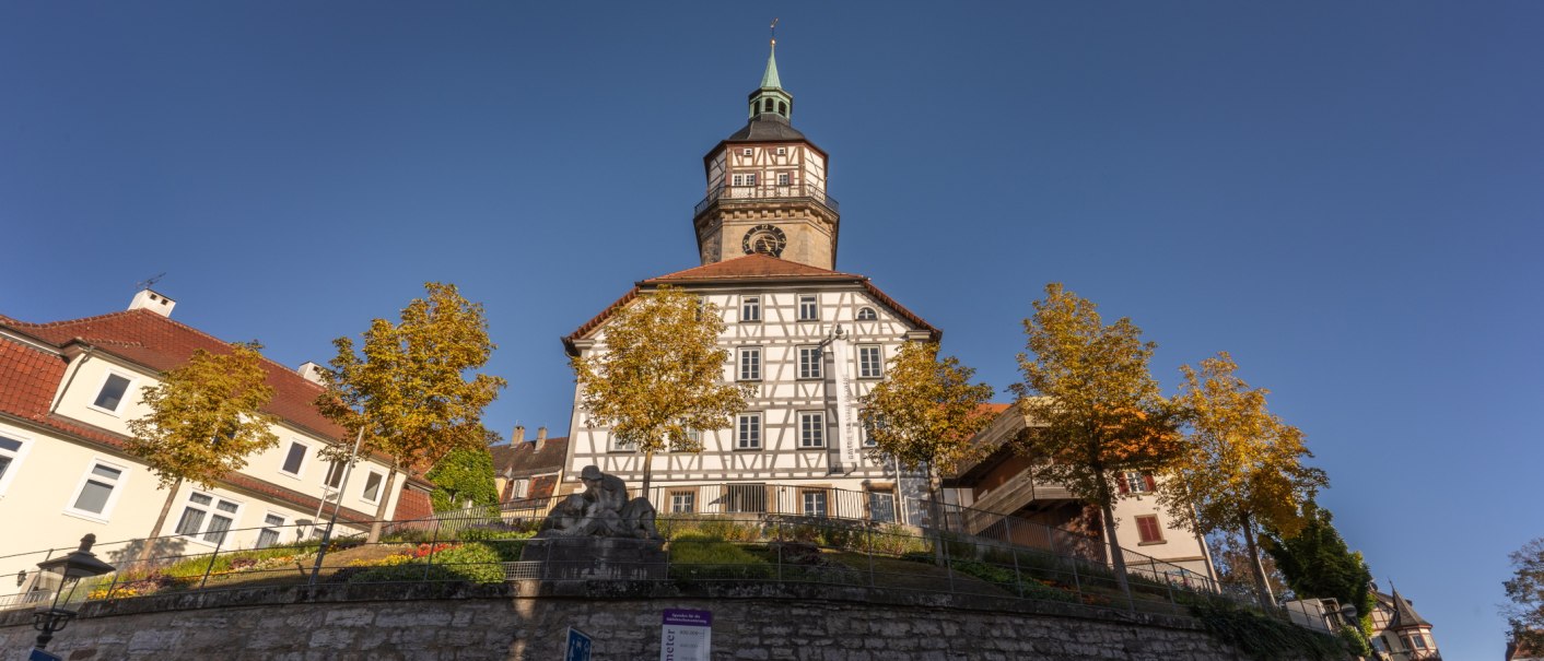 Der Backnanger Stadtturm mit Fachwerkfassade, umgeben von herbstlichen Bäumen und blauen Himmel., © Stuttgart-Marketing GmbH, Martina Denker