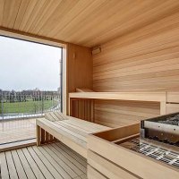 Moderne Sauna mit Holzbänken und großem Fenster, das einen Blick auf eine grüne Landschaft bietet., © Centro Hotels