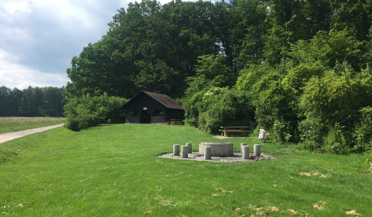 Grillplatz mit Betonfeuerstelle und Holzhütte im Grünen, umgeben von Bäumen und Wiese. Ein Weg führt an der Hütte vorbei., © www.pro-cycl.de Grillplatz mit Betonfeuerstelle und Holzhütte im Grünen, umgeben von Bäumen und Wiese. Ein Weg führt an der Hütte vorbei., © www.pro-cycl.de