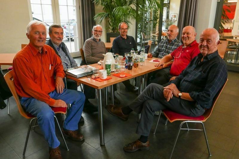 Sieben ältere Männer sitzen lächelnd um einen Tisch in einem Café. Auf dem Tisch stehen Getränke und eine Kaffeekanne., © MGBH Pliensauvorstadt Sieben ältere Männer sitzen lächelnd um einen Tisch in einem Café. Auf dem Tisch stehen Getränke und eine Kaffeekanne., © MGBH Pliensauvorstadt