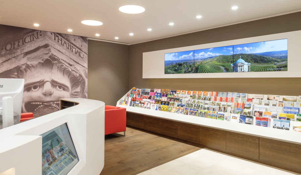 Moderne Touristinformation mit Prospektwand, Bildschirmen und einem Empfangstresen. Ein großes Wandbild zeigt ein antikes Gesicht., © Waiblingen - Stuttgart-Marketing GmbH Moderne Touristinformation mit Prospektwand, Bildschirmen und einem Empfangstresen. Ein großes Wandbild zeigt ein antikes Gesicht., © Waiblingen - Stuttgart-Marketing GmbH