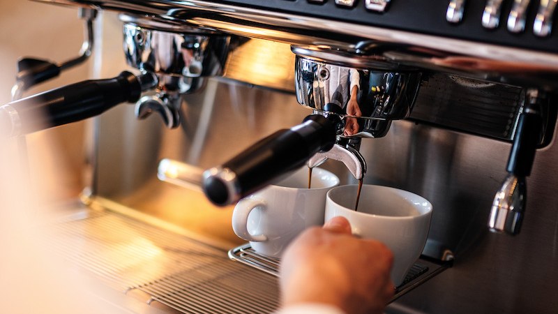 Espressomaschine gie&szlig;t Kaffee in zwei Tassen. Eine Hand h&auml;lt eine Tasse. Beschriftung: "coffee starts here"., &copy; Mercedes-Benz AG