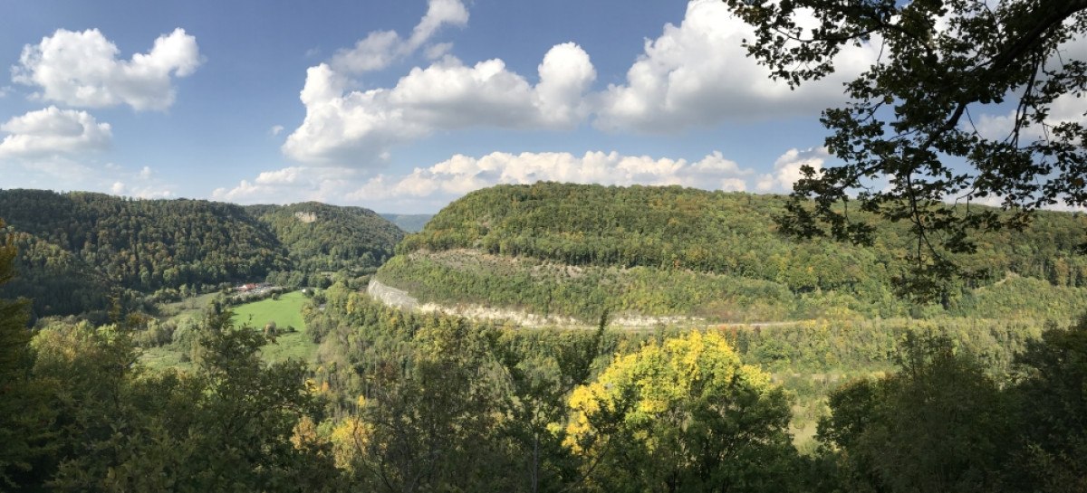 Panoramablick auf eine bewaldete Hügellandschaft mit grünem Tal, blauem Himmel und weißen Wolken., © Landkreis Göppingen