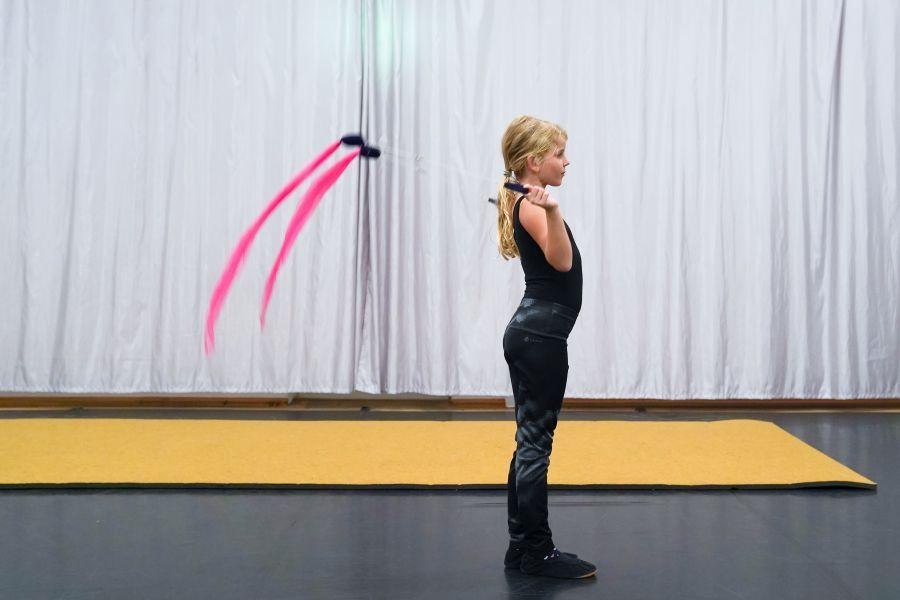 Ein Kind in schwarzer Kleidung steht seitlich mit einem pinken Band in einem Raum mit Vorhang., © Kunstschule Labyrinth Ein Kind in schwarzer Kleidung steht seitlich mit einem pinken Band in einem Raum mit Vorhang., © Kunstschule Labyrinth