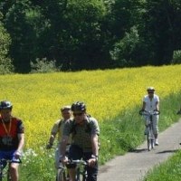 Radfahrer auf einem schmalen Weg neben einem gelben Rapsfeld, umgeben von grüner Natur., © Natur.Nah. Schönbuch & Heckengäu Radfahrer auf einem schmalen Weg neben einem gelben Rapsfeld, umgeben von grüner Natur., © Natur.Nah. Schönbuch & Heckengäu